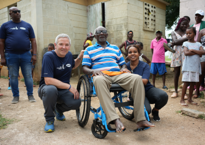 Geoff Purtill and Nuka Solomon posing next to Elgad, our first wheelchair recipient.